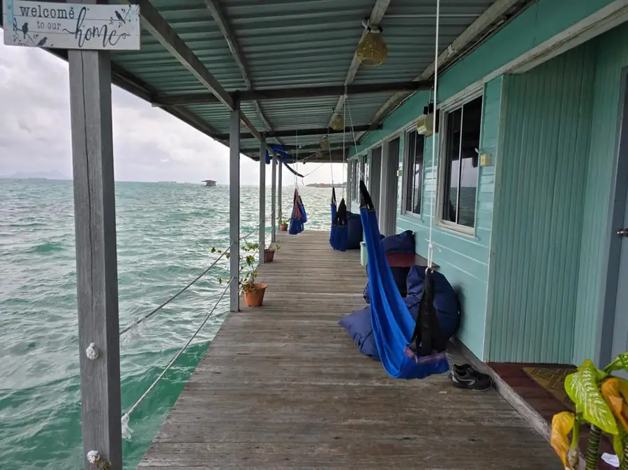 Expansive private outdoor deck with sea views at Bigfin Water Bungalow, featuring relaxing fabric hammocks. A barefoot luxury retreat perfectly suspended over the Celebes Sea.
